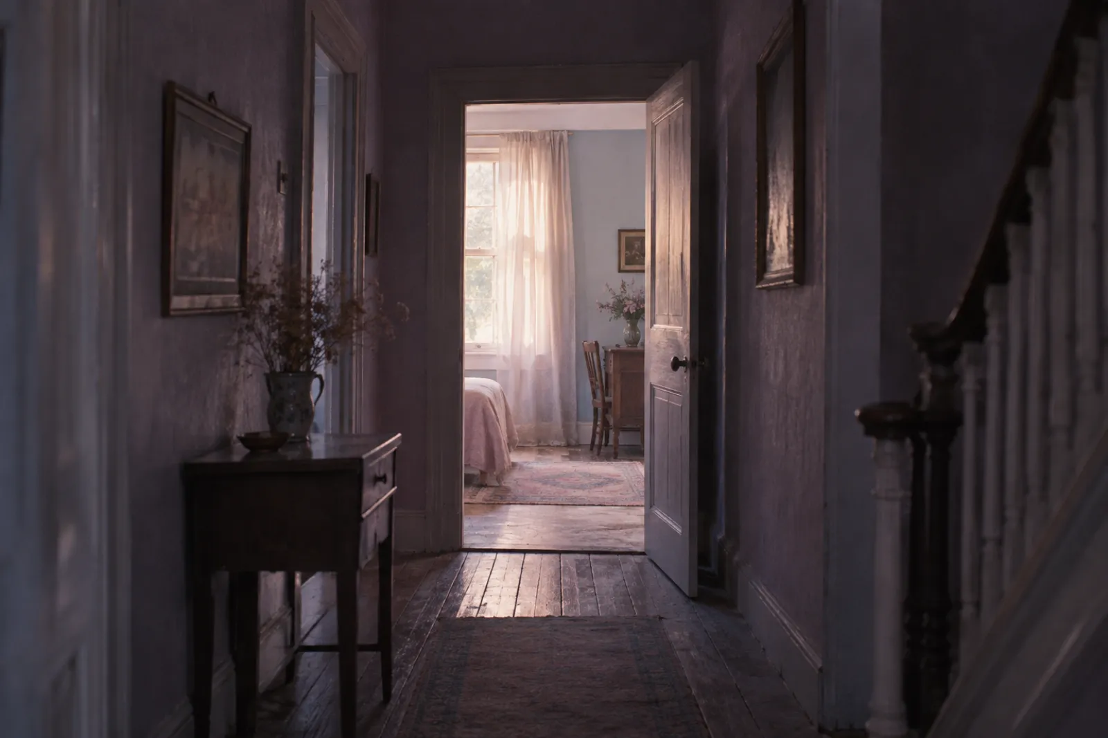 A lit doorway at the end of a dim corridor in an old house